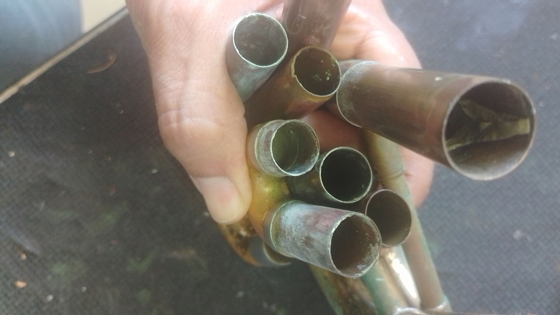 Mano sosteniendo piezas de viento metal